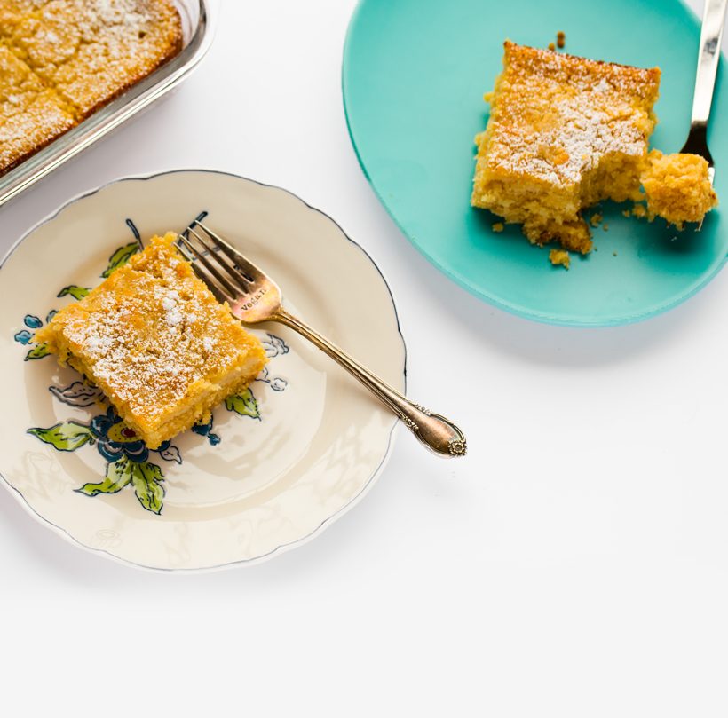 Vegan St. Louis gooey butter cake dusted with powdered sugar, with a moist, soft center.
