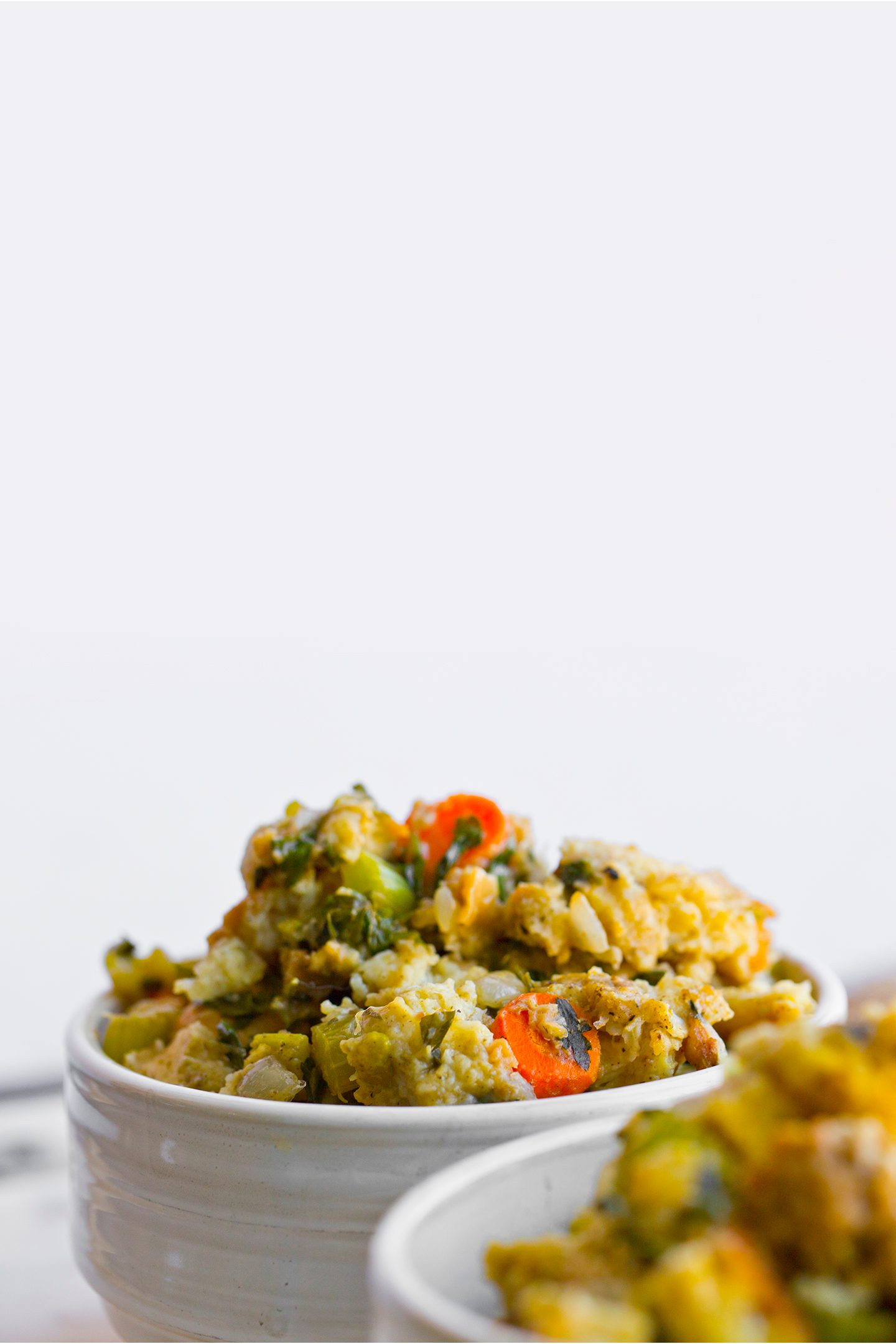 Golden-brown vegan stuffing with bread cubes, celery, carrots, herbs and vegan sausage baked in a casserole dish.