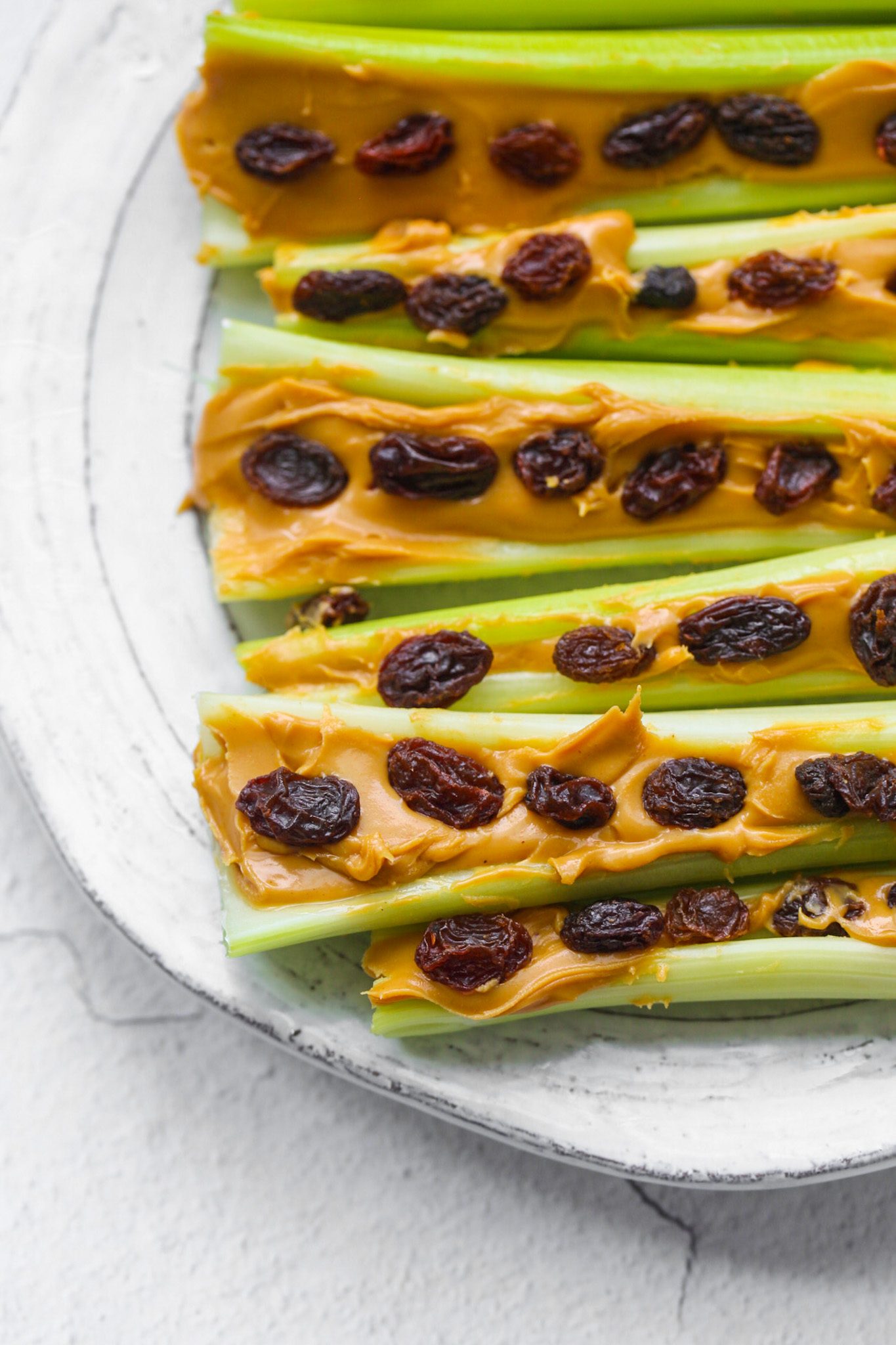 Crunchy celery sticks topped with creamy peanut butter and chewy raisins make a classic ants on a log snack.