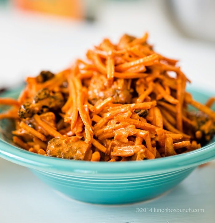 Golden shredded carrot slaw with sweet raisins and creamy tahini dressing seasoned with turmeric and curry.
