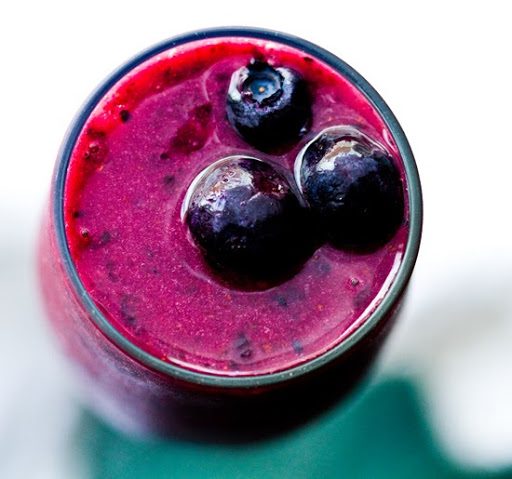 A dark purple blackcurrant and blueberry smoothie with cayenne and vanilla, garnished with blueberries.