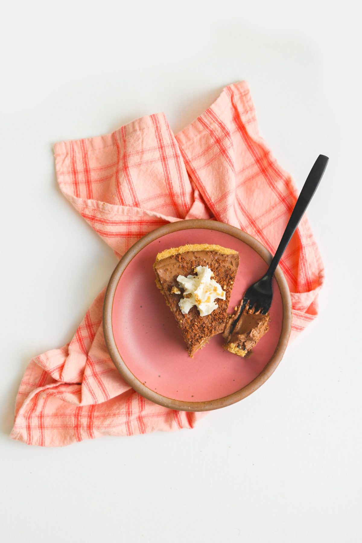Rich vegan chocolate pie in a graham cracker crust topped with non-dairy whipped cream.