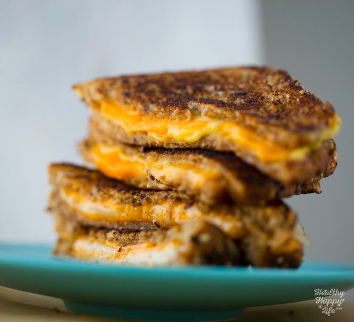 Toasty vegan grilled cheese sandwich with melted American and provolone-style cheeses between buttery slices of bread.
