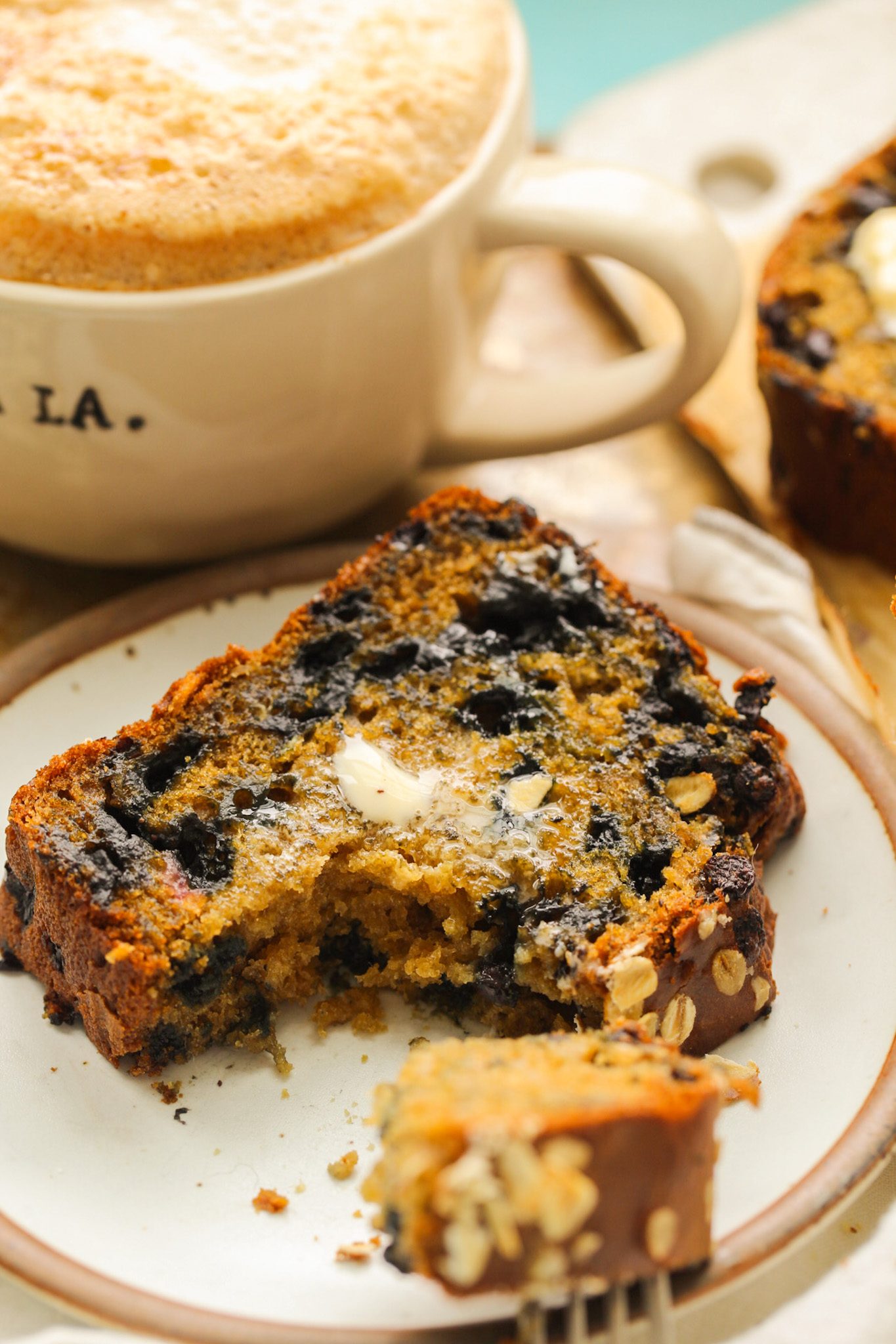 Fluffy blueberry lemon loaf studded with juicy wild blueberries, sliced to reveal its light crumb.