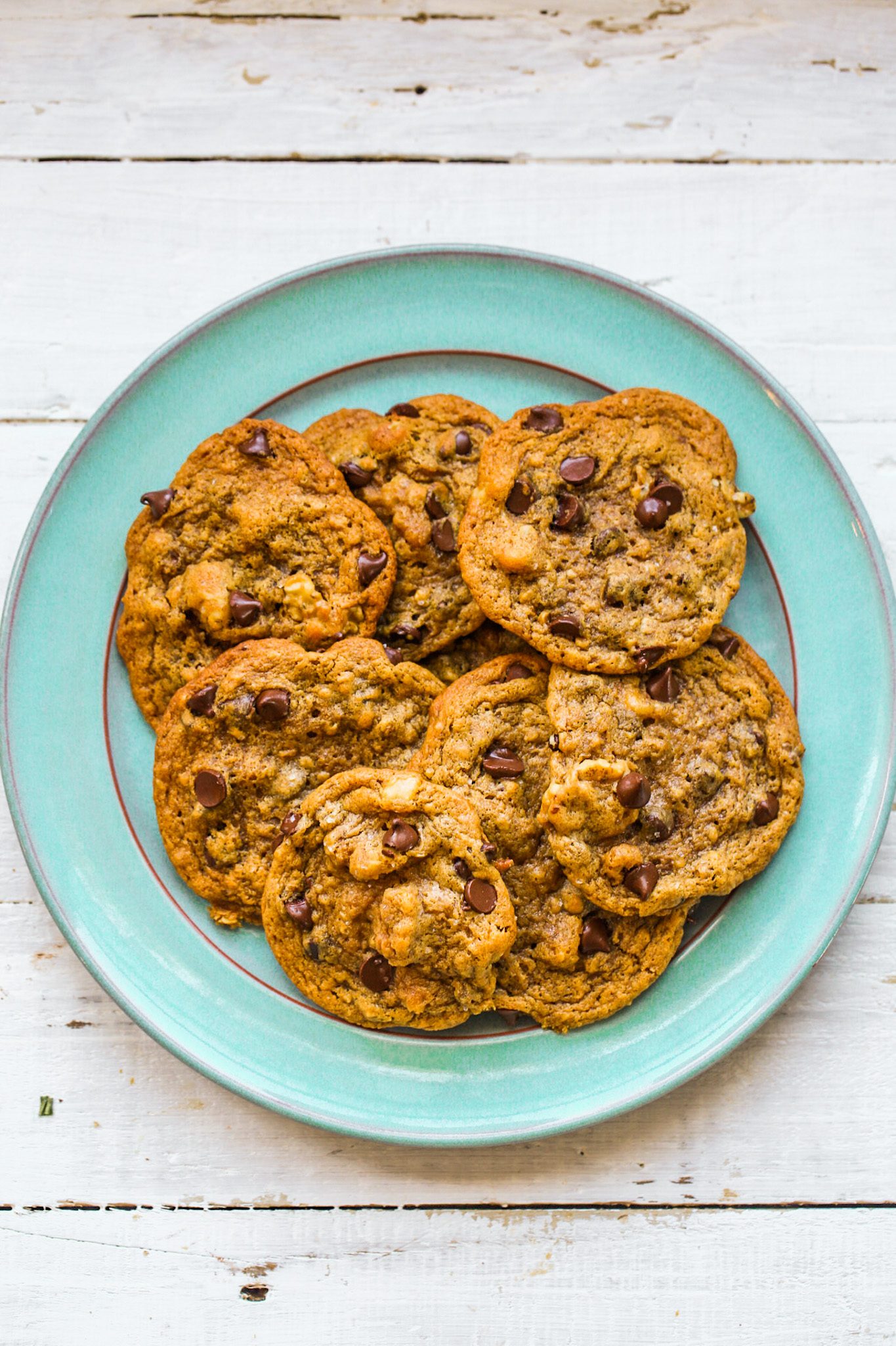 Chewy vegan chocolate chip cookies with walnuts, oats, and melty chocolate chips served on a plate.