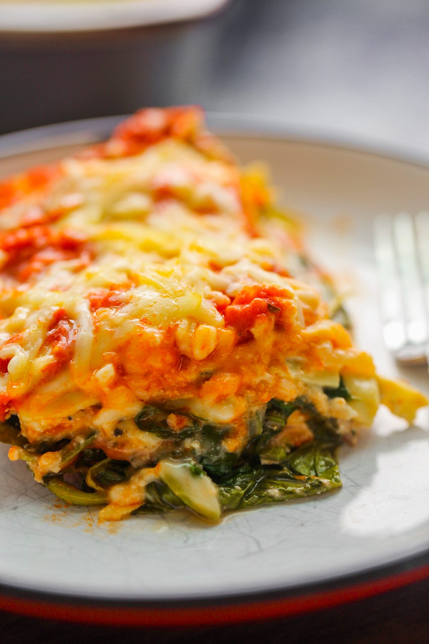 Vegan lasagna with layers of spinach, mushrooms, marinara sauce, creamy cashew ricotta and melted vegan mozzarella.