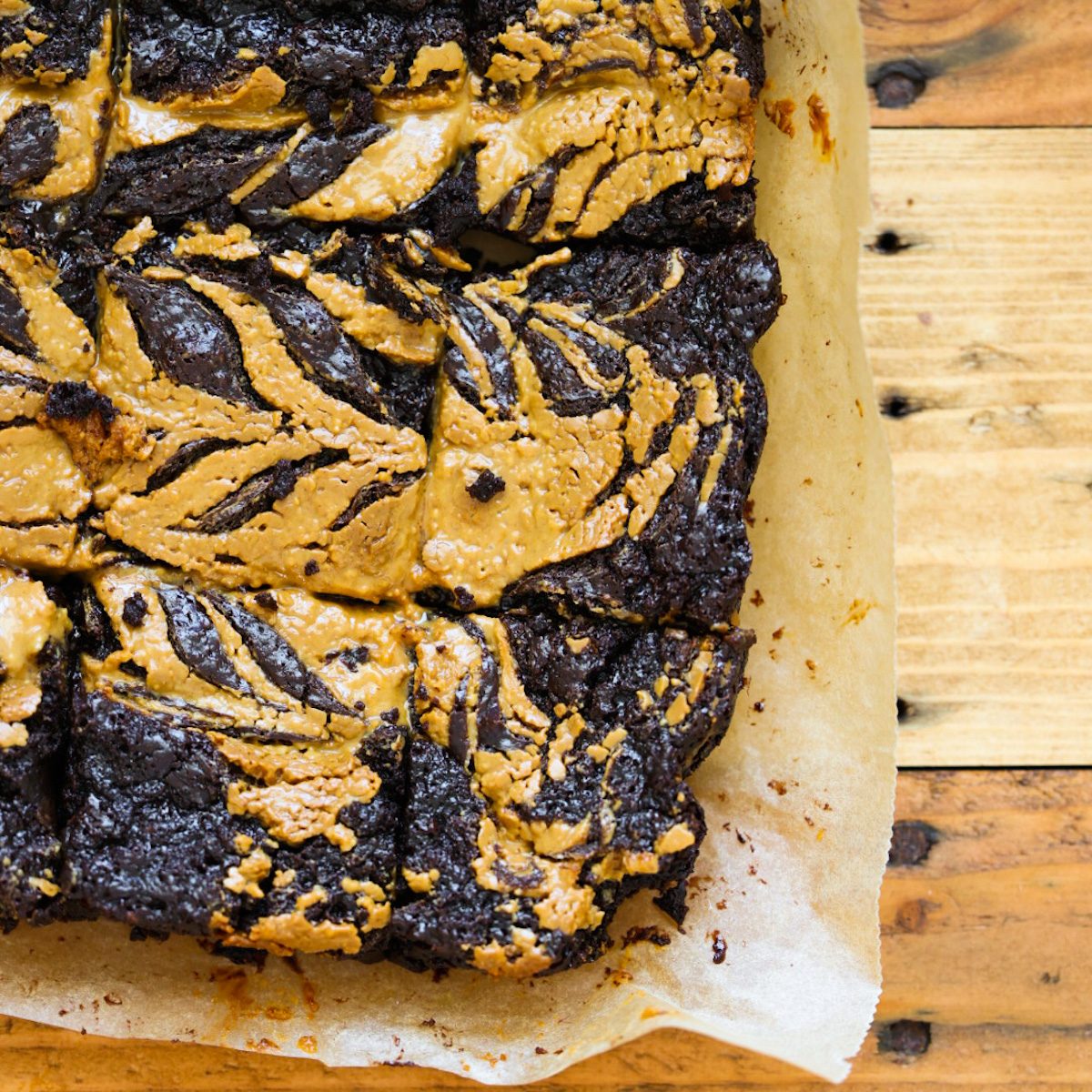 Rich, fudgy vegan chocolate brownies topped with swirls of peanut butter and cut into squares.