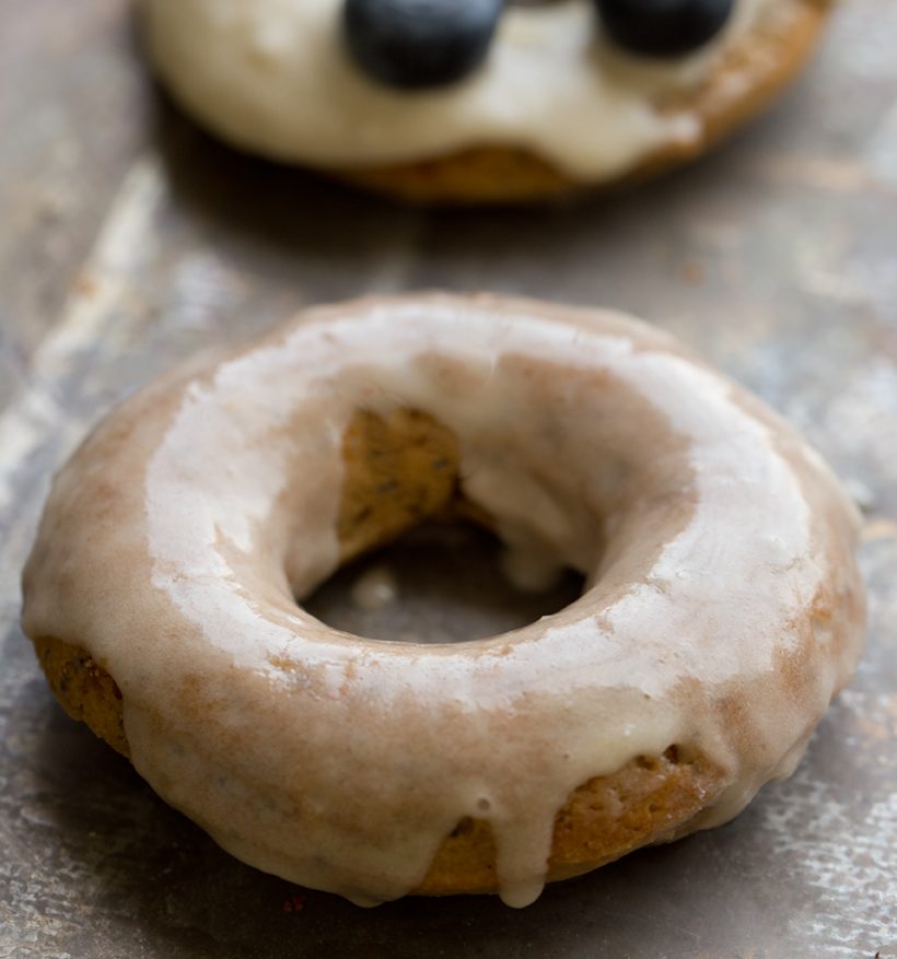 Baked lemon poppyseed donuts topped with vanilla frosting and fresh blueberries.