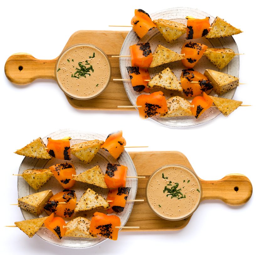 Salt and pepper tofu triangles on skewers with roasted bell peppers, served with a rich peanut dipping sauce.
