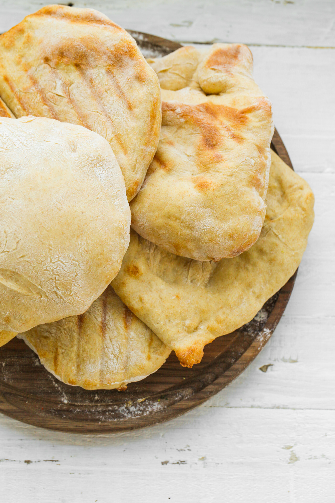 Fluffy homemade pita bread with lightly browned surfaces and airy pockets ready for stuffing.