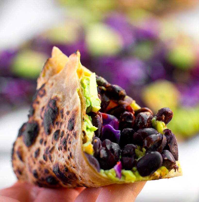Crispy-edged tortilla pizzas topped with smashed avocado, mushrooms, and assorted vegetables.