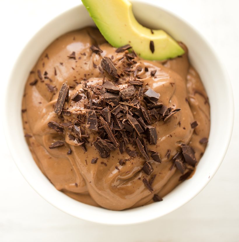 Silky vegan chocolate avocado mousse served in cups and topped with finely chopped chocolate.
