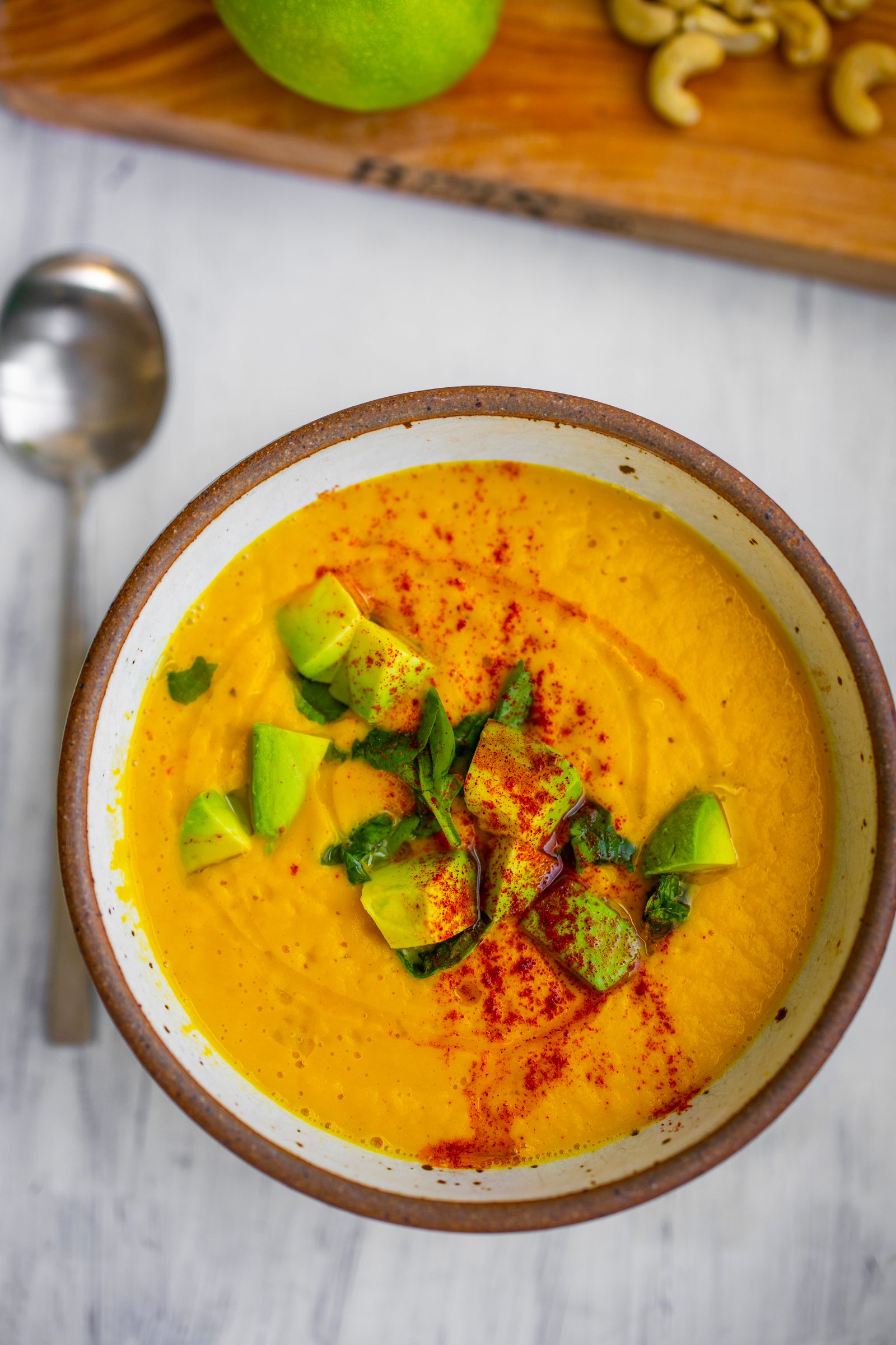 Silky golden butternut squash soup topped with avocado, greens, olive oil and paprika.