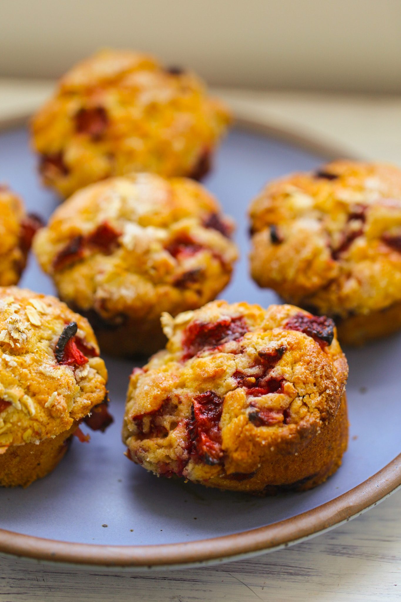 Vegan strawberry muffins studded with juicy berries, with fluffy crumb and sugary domed tops.