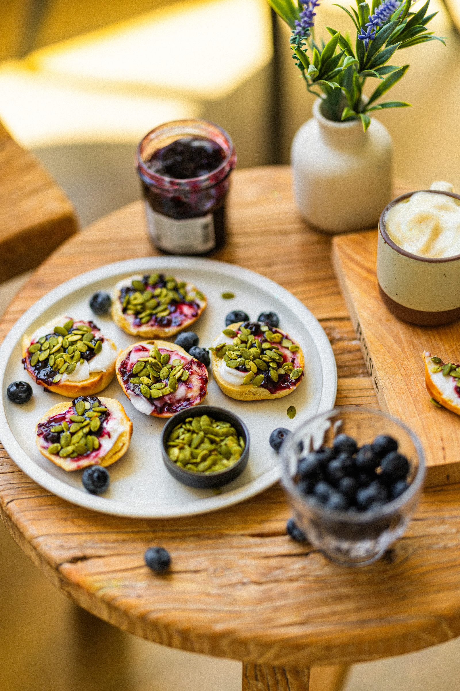 Mini bagels topped with vegan cream cheese, mixed berry jam and pumpkin seeds.