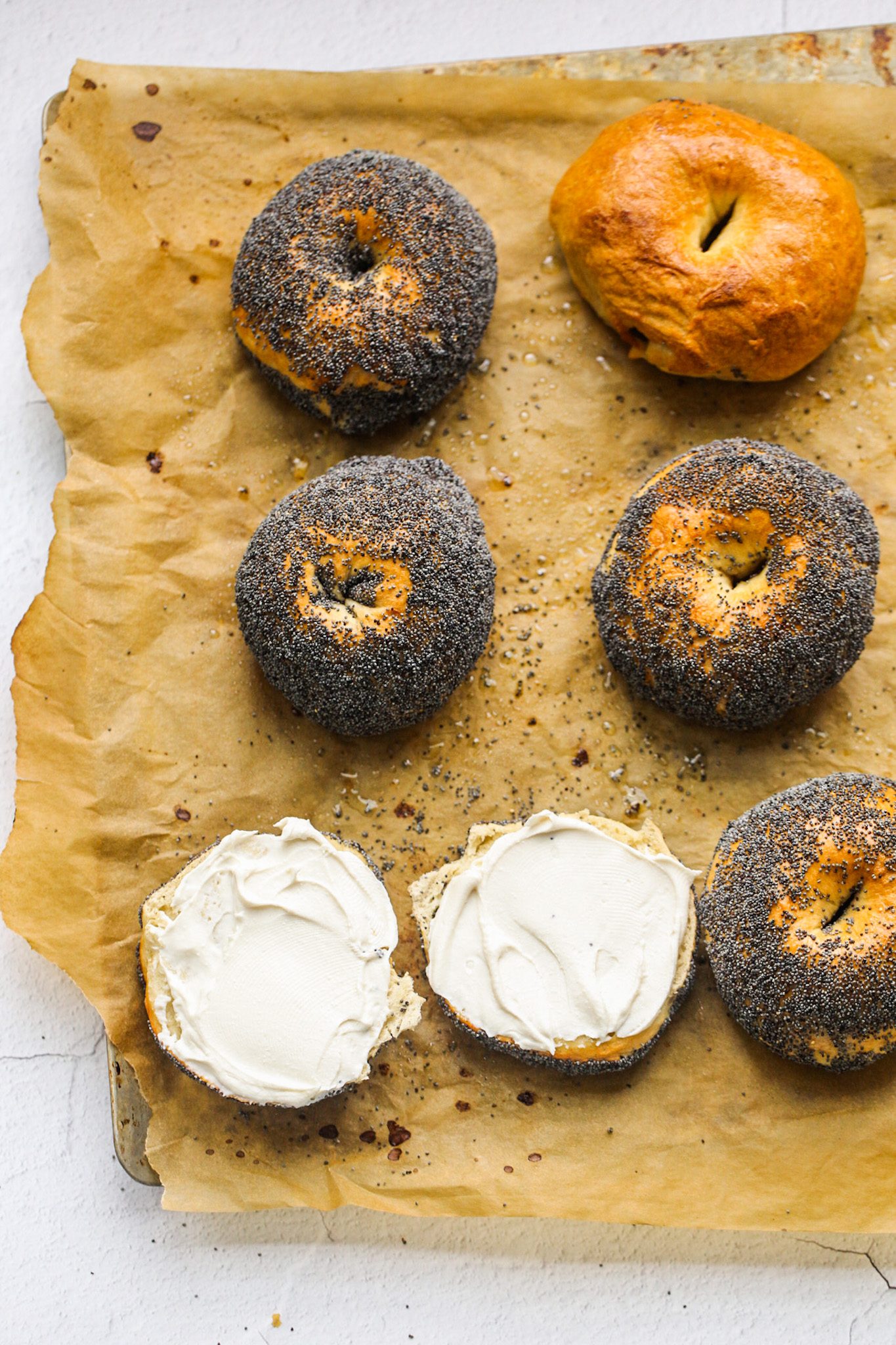 Homemade bagels with chewy crusts and fluffy interiors, including plain and seed-topped varieties.