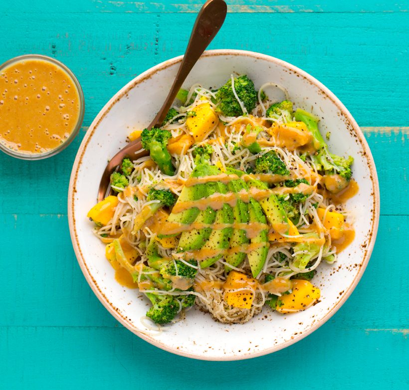 Rice noodles tossed with broccoli and diced mango, topped with sliced avocado and peanut sauce.