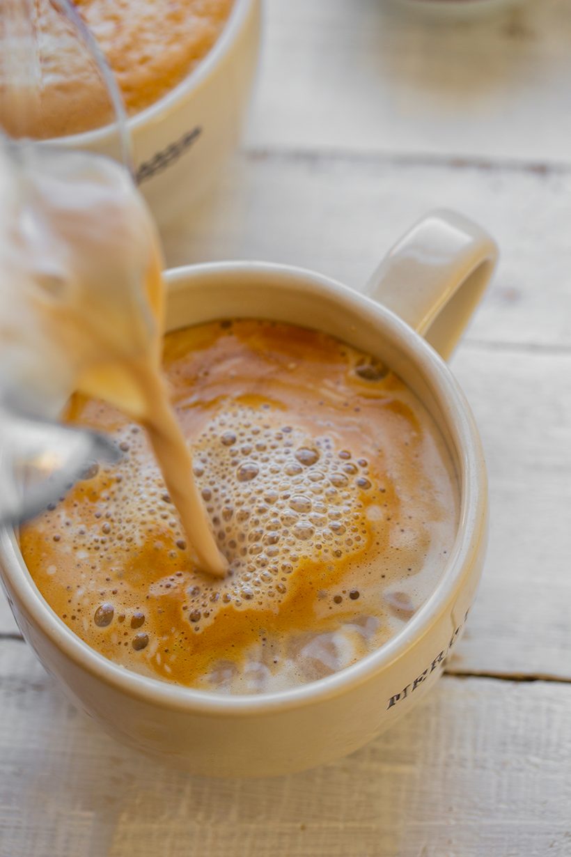 A frothy cinnamon soy latte made with espresso and coconut sugar, served in a mug.
