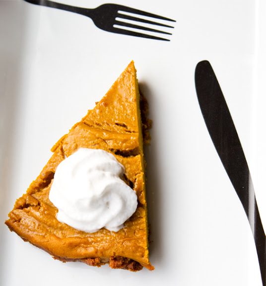 Hubbard pumpkin pie with a glossy golden-amber filling and a dense, silky texture in a cookie crumb crust.