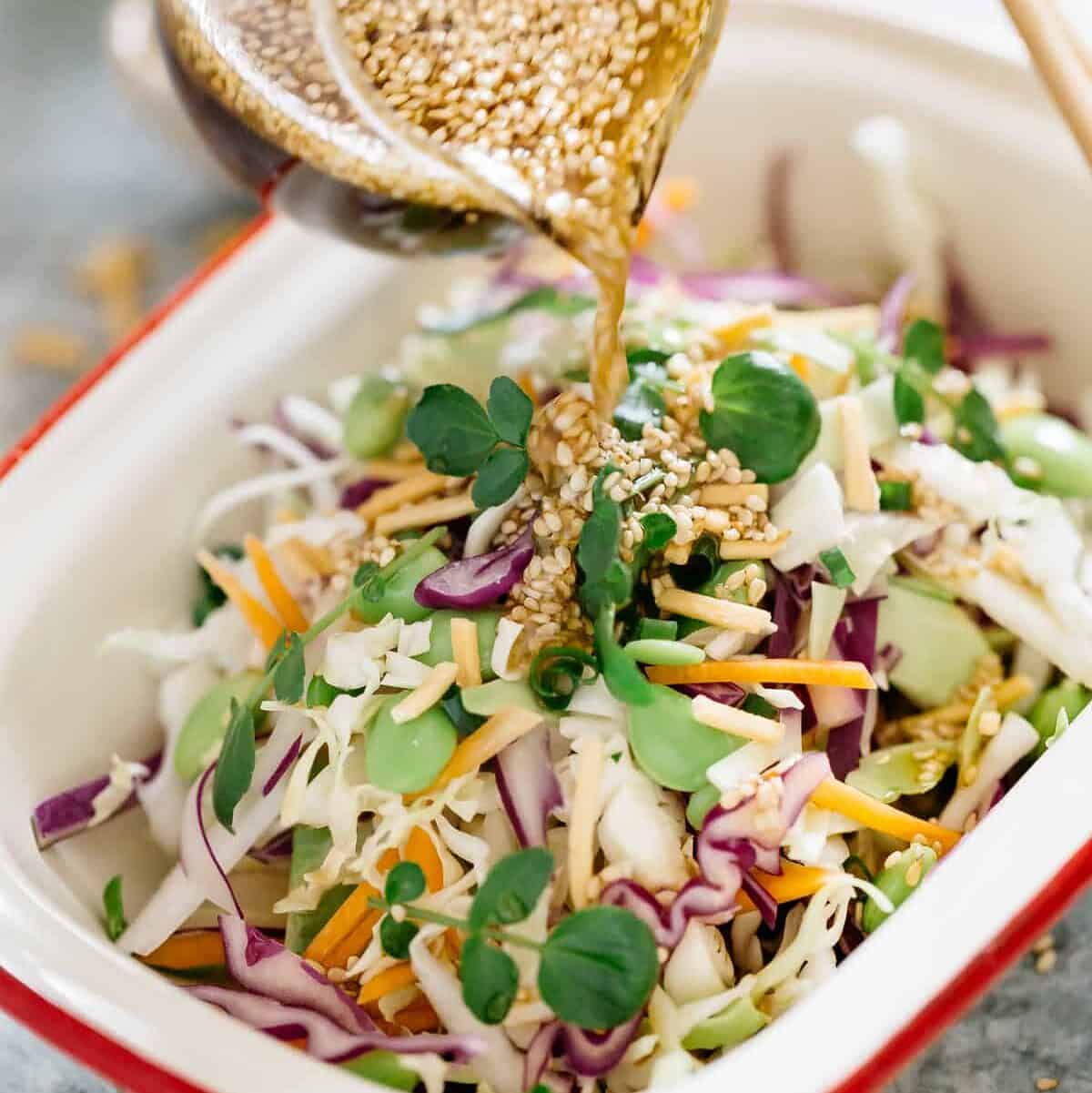A fresh Asian-style slaw with crisp vegetables, herbs, and noodles, drizzled with a savoury sesame dressing